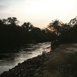 Scenic view of river against sky at sunset