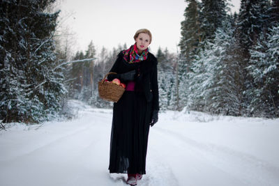 Woman covering face on snow covered landscape