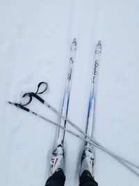 Low section of person on snow covered shoes