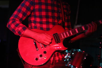 Midsection of man playing guitar