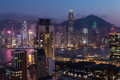 Illuminated buildings in city against sky at night