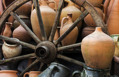 Wagon wheel amidst pottery for sale