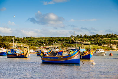 Boats moored in sea against sky