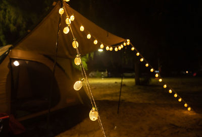 Decorative lights in front of tourists' tents at night.