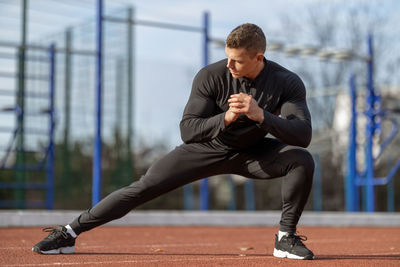 Low section of young man exercising in gym