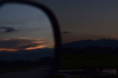 Scenic view of silhouette field against sky during sunset