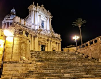 Low angle view of illuminated building against sky at night