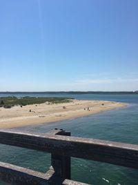 Scenic view of beach against clear blue sky