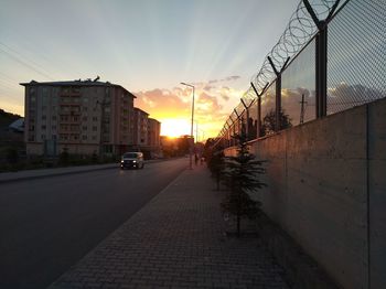 Cars on street in city at sunset