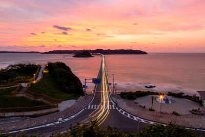 High angle view of road by sea against sky during sunset