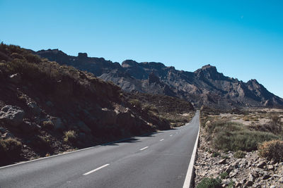 Road amidst mountains against clear sky