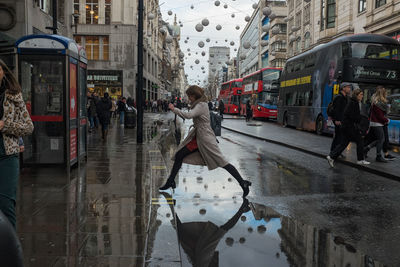 People walking on wet street during rainy season