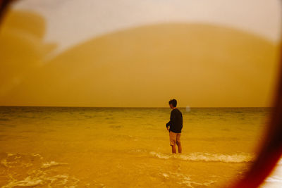 Rear view of man standing on beach