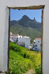 Buildings by mountains against sky