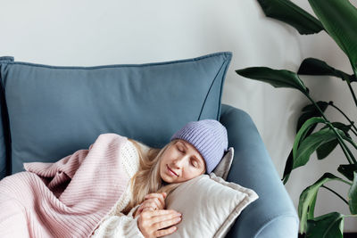 Rear view of woman sitting on sofa at home