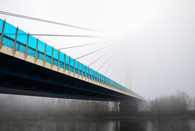 Low angle view of bridge over river against sky