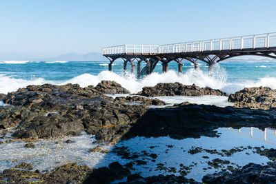 Bridge over sea against clear sky