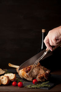 Close-up of hand holding food against black background