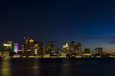 Illuminated buildings in city against sky at night