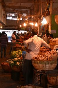 Rear view of people working at market stall