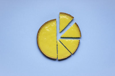 Directly above shot of lemon slice against blue background