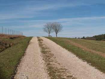 Road amidst field against sky