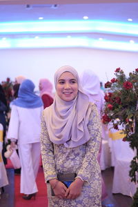 Smiling woman in traditional clothing during wedding ceremony