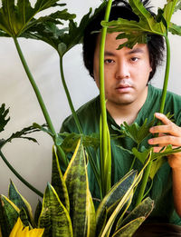 Portrait of young man with plants.