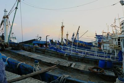 Boats moored at harbor against clear sky