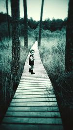 Woman walking on boardwalk