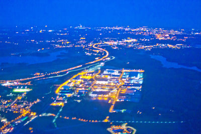 High angle view of illuminated cityscape against sky at night