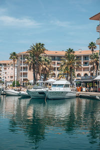 Boats moored in sea against buildings in city