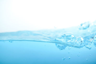 Close-up of water splashing against blue background