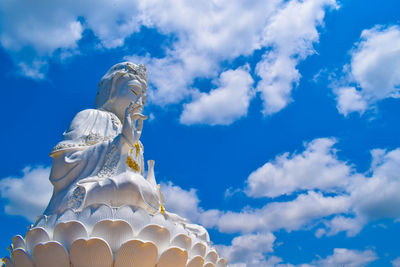 Low angle view of statue against cloudy blue sky