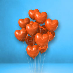 High angle view of heart shaped balloons against blue background