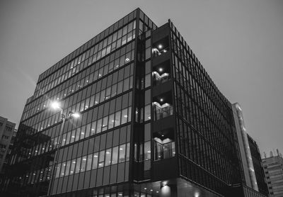 Low angle view of illuminated buildings against clear sky at night