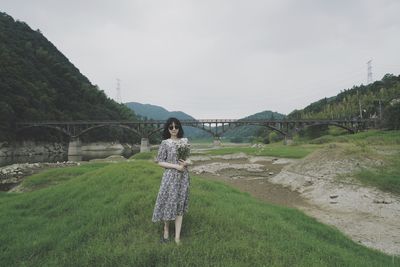 Woman standing on field against sky