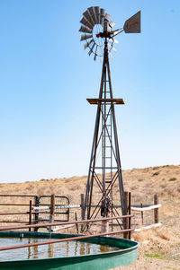 Traditional windmill on field against clear sky