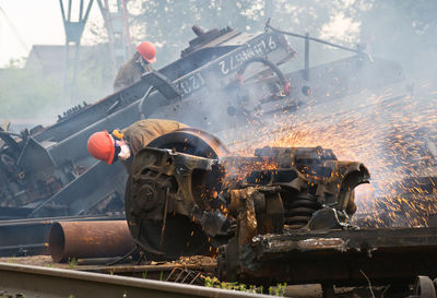 Welder welding scrap metal of train