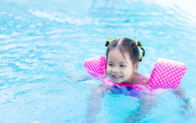 High angle view of smiling girl swimming in pool