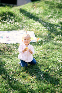 Portrait of cute baby girl on field