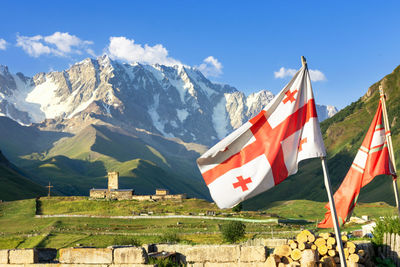 Georgia flag against the background of the caucasus mountains, ushguli, svaneti, caucasus, georgia