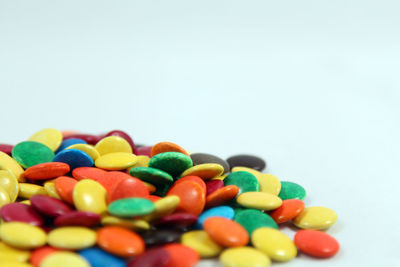 Close-up of multi colored candies against white background