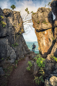 People on rock formations against sky