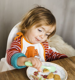 Cute girl eating food at table