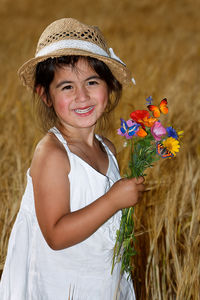 Portrait of a smiling girl with red flower