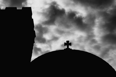 Low angle view of silhouette built structure against sky