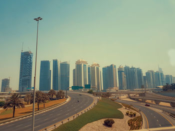 Panoramic view of city street and buildings against clear sky