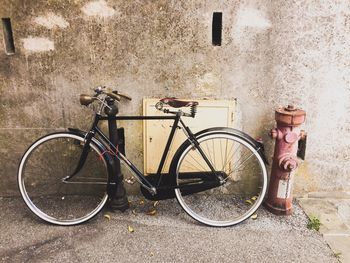 Bicycle parked against wall in city