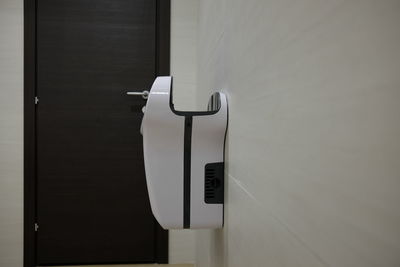 Close-up of hand dryer on wall in bathroom